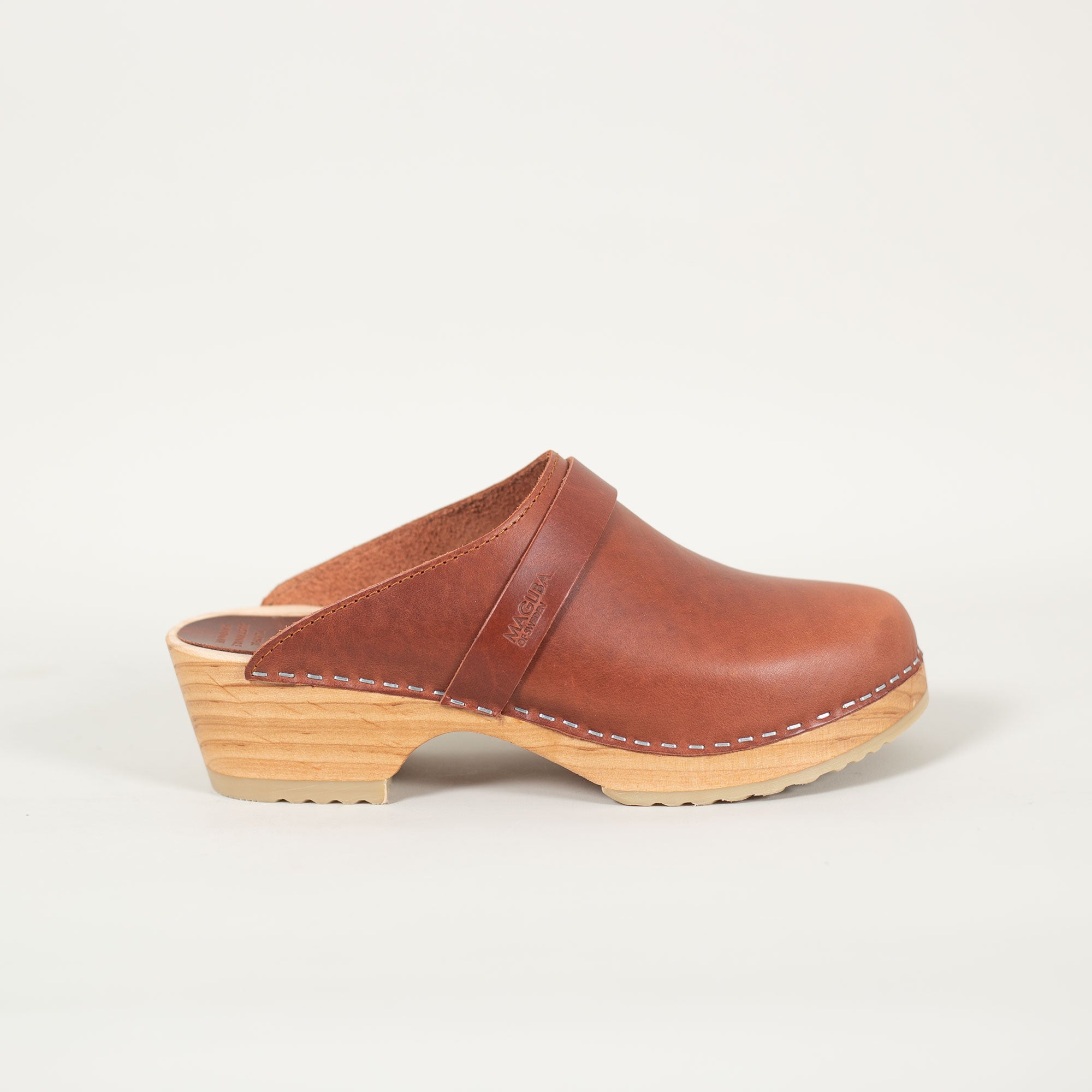 Berkeley clogs in brown pull up leather on a natural wooden bottom