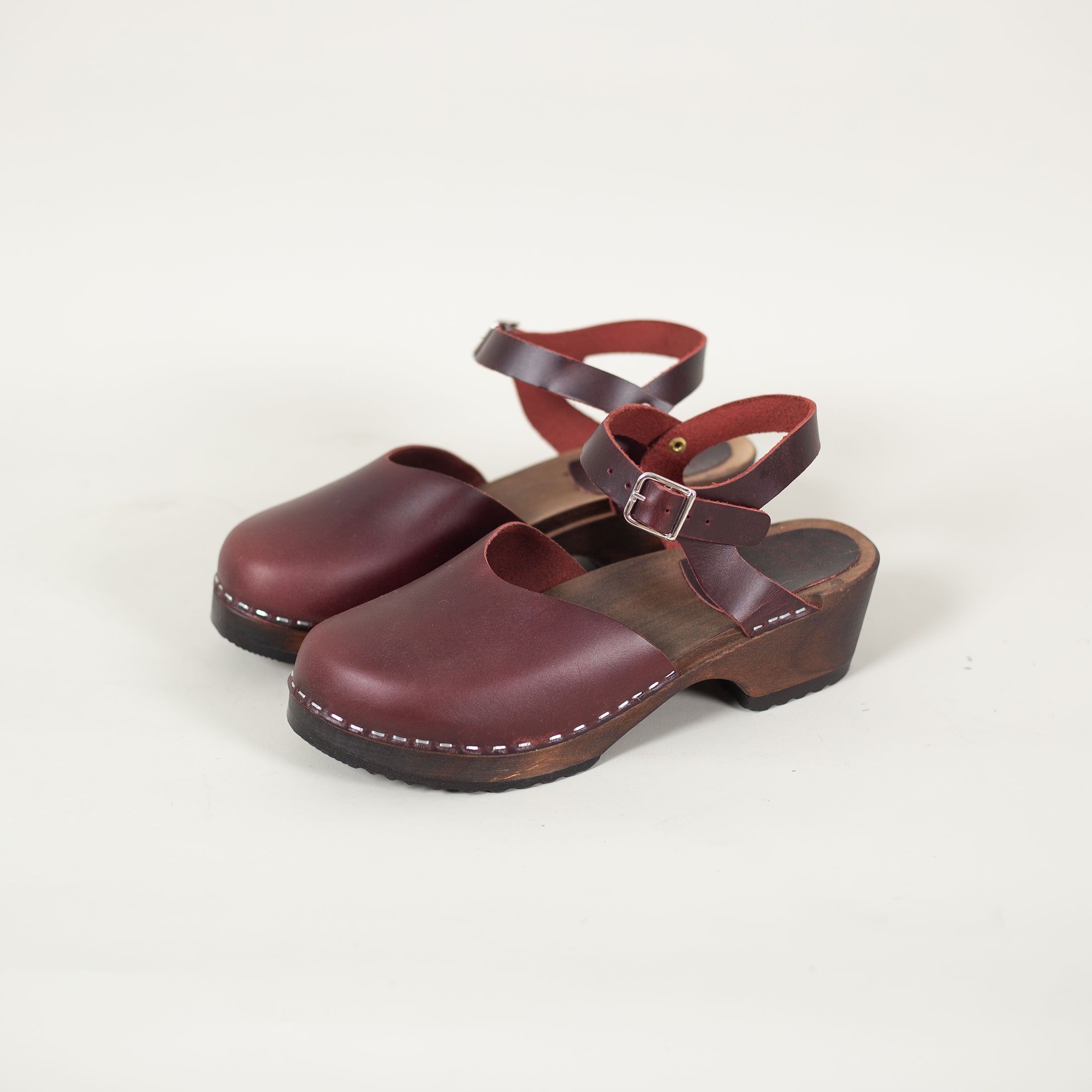 Low heel Swedish leather sandals in burgundy with comfortable wooden base and secure strap.