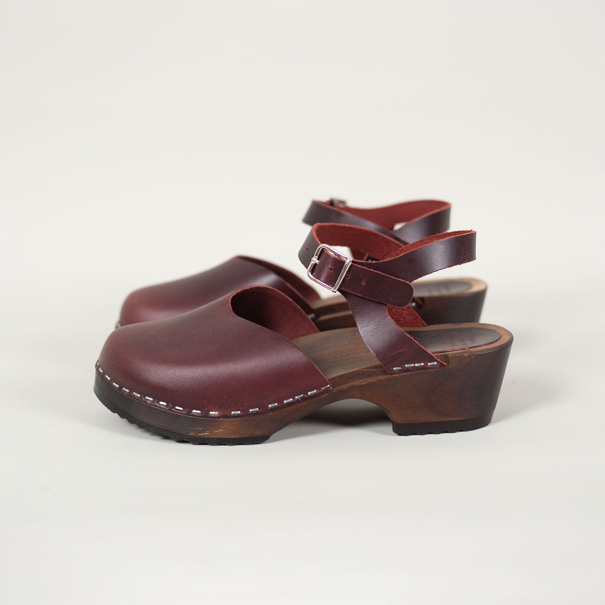 Handmade Burgundy leather clog sandals with wooden sole and ankle strap.